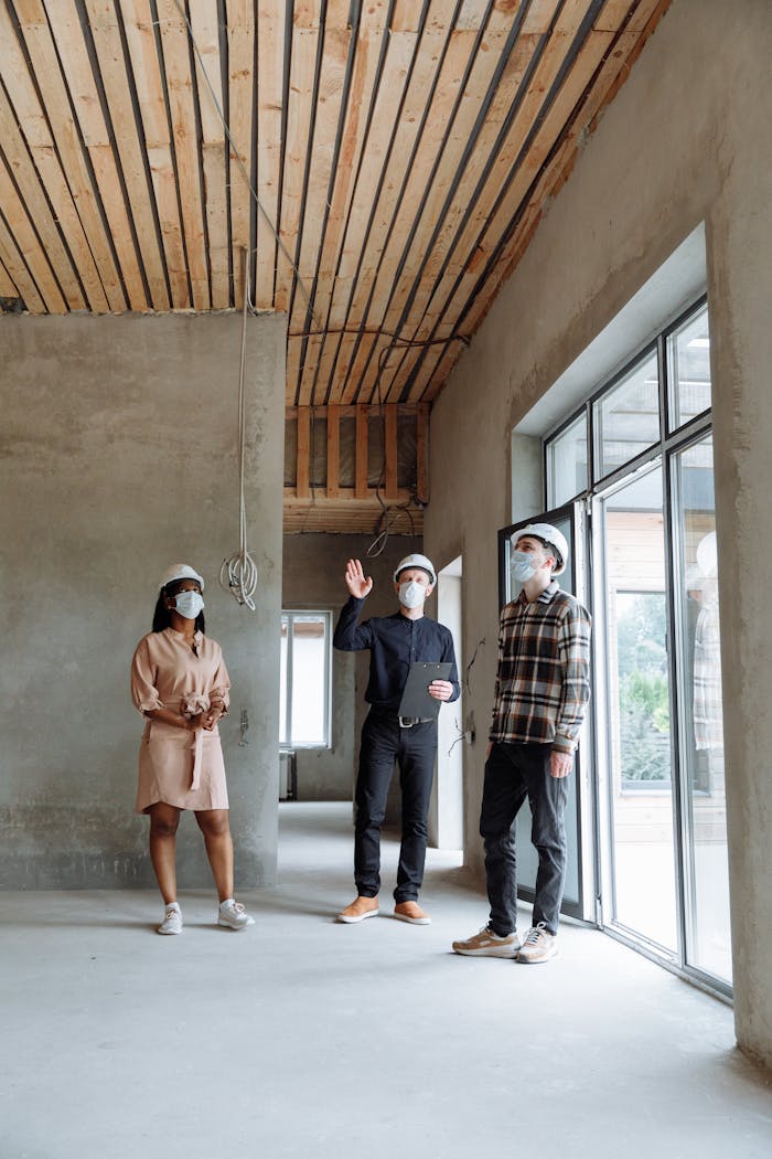 Construction professionals discussing progress with safety measures in a modern building environment.